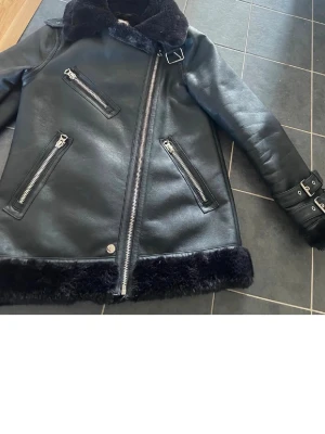 Läderjacka med päls  - Säljer en jättefin läderjacka  med svart päls inuti och runt kragen, ärmar och nedtill🩷Jackan är ifrån warehouse i storlek 6. Passar mig som är en Xs- S i storlek.