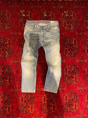 Archive Diesel Jeans - Säljer ett par ljusblå jeans från Diesel med snyggt tvättad effekt och klassisk femficksmodell. Perfekta för dig som gillar avslappnad stil och vill ha ett par jeans som sticker ut. Undrar du något är det bara att skriva😁🙌