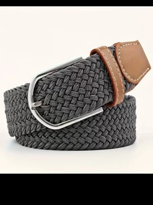 Grått flätat bälte med läderdetaljer - Snyggt grått flätat bälte med silverfärgat spänne och bruna läderdetaljer. Perfekt accessoar för att lyfta din outfit och funkar till både jeans och chinos. Klassisk design med modern twist.