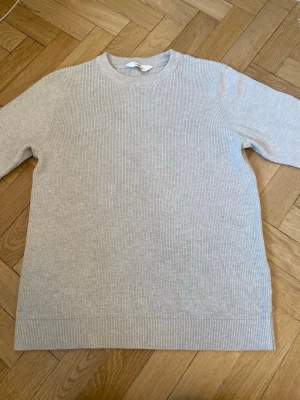 Beige stickad tröja från hm - Säljer en stilren beige stickad tröja från Hm . Tröjan har rund halsringning, ribbade muddar och är gjord i ett mjukt, tunt material. Perfekt basplagg med enkel design och lång ärm. Passar till allt och är superenkel att styla.