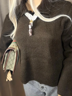 Mörkbrun stickad tröja med krage - Mysig mörkbrun stickad tröja med klassisk krage och lång ärm. Tröjan har en enkel, rak passform och är tillverkad i ett mjukt stickat material. Perfekt att matcha med jeans eller kjol för en avslappnad look.