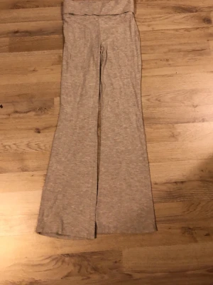 gråa utsvängda leggings med medel midja - Snygga gråa leggings med utsvängda ben och medel midja. Tillverkade i mjukt stretchigt material som sitter skönt på kroppen. Perfekta för en avslappnad och trendig look.