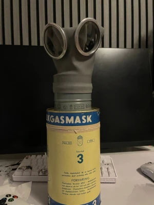 Svensk gasmask Typ 32 storlek 3 - Cool grå gasmask av modellen Typ 32, storlek 3, med stora runda glasögon och justerbara remmar. Perfekt till maskerad eller cosplay där du vill sticka ut med en autentisk militär look. Kommer i originalförpackning med tydlig märkning.