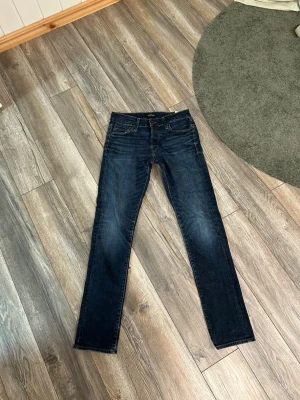 Jack & Jones Slim/Glenn - Snygga mörkblå jeans med raka ben och klassisk femficksdesign. Jeansen har subtila slitningar framtill och kontrastsömmar. Passar perfekt till en avslappnad stil och är tillverkade i denim med en skön känsla.