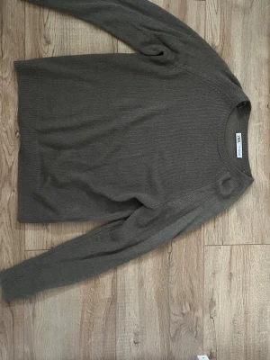 Mörkgrå stickad tröja från Zara - Säljer en mörkgrå stickad tröja från Zara med rund halsringning och långa ärmar. Tröjan har en tunn, mjuk stickning som passar perfekt till lager på lager och ger en avslappnad men stilren look! Säljer för den kommer tyvärr inte till användning 