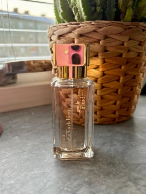 Maison Francis Kurkdjian Gentle Fluidity gold - Exklusiv parfym från Maison Francis Kurkdjian i modellen Gentle Fluidity gold. Flaskan är genomskinlig med guldiga detaljer och fyrkantig form. Locket är blankt och guldfärgat, vilket ger en lyxig känsla. Perfekt för dig som gillar eleganta och moderna dofter. 35 ml endast testad