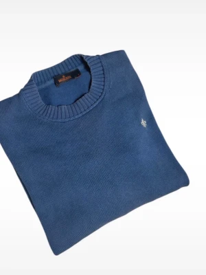 Blå stickad tröja Morris - Blå stickad tröja från Morris med rund halsringning och ribbade muddar. Tröjan har en liten broderad logga på bröstet och är tillverkad i ett mjukt material som passar perfekt för lager-på-lager. Enkel och stilren design.