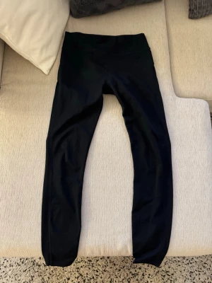 Svarta leggings från Nelly - Säljer ett par klassiska svarta leggings från Nelly med medelhög midja och stretchigt material. Perfekta för en avslappnad look och superbekväma att bära hela dagen. Passar till det mesta och har en enkel, stilren design.