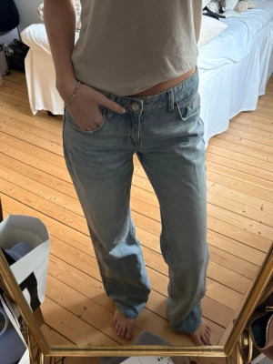 Ljusblå raka jeans med låg midja - Säljer ett par ljusblå jeans med rak passform och låg midja. Jeansen har klassisk femficksdesign och är gjorda i denim. Perfekt för dig som gillar en avslappnad och trendig stil.