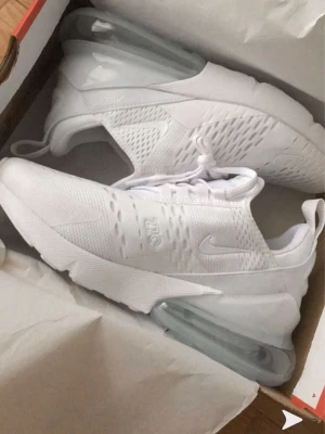 Nike Air Max 270 vita sneakers - Säljer mina Nike Air Max 270 i storlek 36. De är använda ett par få gånger men kommer tyvärr inte till användning längre.  Skorna är i fint skick och bekväma att gå i. Den helvita färgen gör dem lätta att matcha till det mesta. Inga större skador eller slitage, se bilder för skick. Skorna är dock lite smutsiga men det går enkelt bort med en tvätt. Fråga om bilder så visar jag  – Märke: Nike – Modell: Air Max 270 – Storlek: 36 – Färg: Vit – Skick: Använda få gånger  📦 Skickas snabbt 💬 Dm vid fråg