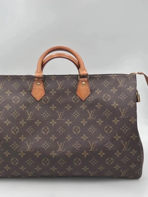 Louis Vuitton monogram handväska - Tidlös investering. Begagnad lyxväska LOUIS VUITTON SPEEDY 40 Monogram. Mångsidig och slitstark väska som erbjuder ikonisk stil och premiumkvalitet. Mycket rymlig och bekväm att bära varje dag.