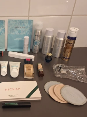Stort kit med skönhetsprodukter - Ett blandat kit med skönhetsprodukter som inkluderar ansiktsmasker från Hickap, sminkborttagningspads, ögonfransböjare, foundation, ögonskuggspalett, hårspray, läppbalsam, 2 mascaror två ansiktsmasker. Märken dom Isadora, Yves rocher, Bangerhead, Biothetrm dom två av sakerna är testade. Hickap parfym från versage 5 ml