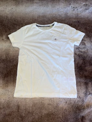 Helt ny Gant T-shirt - Hej! Säljer en helt ny gant T-shirt. Tröjan är aldrig använd och har inga hål/fläckar eller liknande. Säljes pga att den köptes i fel storlek. Lappen sitter kvar som ni ser på bilden!🤗