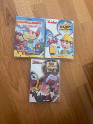 Disney Junior DVD-böcker, 3 st - Tre DVD-böcker från Disney Junior: två med Händige Manny (volym 3 och 9) och en med Jake och piraterna i Landet Ingenstans (volym 6). Omslagen är färgglada med tecknade figurer och tydliga titlar. Perfekt för dig som gillar barnprogram och samlar på Disney.