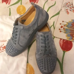 Blå mocka sneakers från Louboutin - Säljer ett par blå sneakers från Christian Louboutin i storlek 40 men passar även 41.Har tyvärr ingen box och ett spik har lossnat.Kan mötas upp i Stockholm stad. Endast swish.Pris kan diskuteras.skor loubs blå