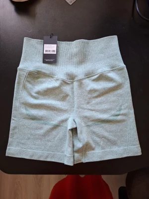 Ljusgröna sömlösa träningstights-shorts - Snygga ljusgröna sömlösa shorts med hög midja och ribbad linning. Perfekta för träning eller chill, i mjukt och stretchigt material som sitter skönt på kroppen. Enkel design utan fickor eller dragkedjor.