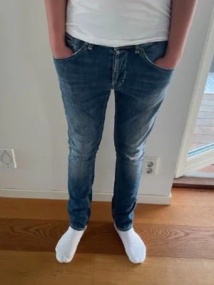 Blå slim fit dondup jeans - Säljer ett par riktigt snygga dondup jeans med snygga slitningar! De är i väldigt fint skick ( helt oanvända)  nypris runt 4000. Skriv vid minsta fråga eller fundering!🙌