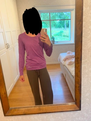 Lila långärmad träningströja från RONHILL - Lila långärmad träningströja från RONHILL med rund hals och logga vid nederkanten. Tröjan är i ett tunt tyg som är perfekt för träning. Nästan helt oanvänd.