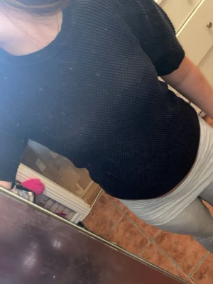 Svart stickad topp med puffärm - Säljer en svart stickad topp med korta puffärmar och rund halsringning. Tröjan har en diskret struktur i stickningen och ribbade muddar vid ärmslut och nederkant. Perfekt till jeans eller kjol för en trendig look.