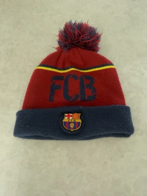FC Barcelona mössa  - FC Barcelona mössa köpt i deras officiella butik på Camp Nou 2013. Storleken är one size men passar mer för äldre barn/mindre huvuden. 