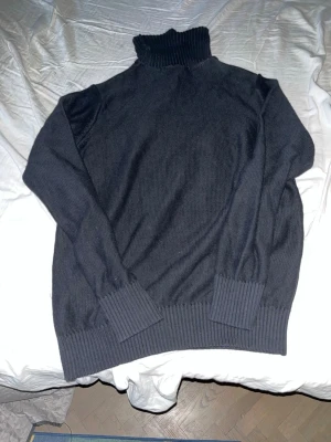 Mörkblå selected tröja  - Mysig mörkblå stickad  selected med bred ribbad mudd vid ärmslut och nederkant. Tröjan har en hög polokrage och lång ärm, perfekt för kyliga dagar. Enkel och stilren design som funkar till det mesta.