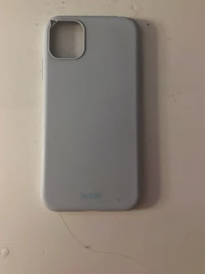 Ljusblått mobilskal i silikon (iphone11) - Snyggt ljusblått mobilskal till iPhone 11 i mjukt silikonmaterial. Skalets design är enkel och stilren med rundade hörn och ett stort kamerahål. Passar perfekt för dig som vill ha ett minimalistiskt skydd till din mobil. Priset kan diskuteras.