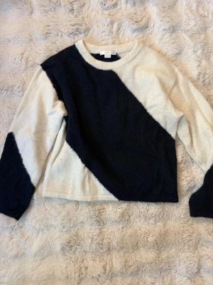 Stickad tröja från Gina Tricot - Säljer en snygg stickad tröja från Gina Tricot i storlek 146/152. Tröjan har ett coolt diagonalt mönster i blå och vitt, rund halsringning och långa ärmar. Perfekt för dig som gillar en trendig och bekväm stil.