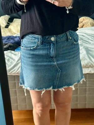 Gina Tricot jeanskjol med fransig kant - Säljer en helt ny blå jeanskjol från GinaTricot. Klassiskmodell med rå, fransig kant nertill. Kjolen har fem fickor, bälteshällor och stängs med knapp och dragkedja framtill. Perfekt för dig som gillar en avslappnad och trendig stil. Köpte fel storlek och prislapparna har tyvärr hunnits tas bort. Ej använd. Nypris 399kr.