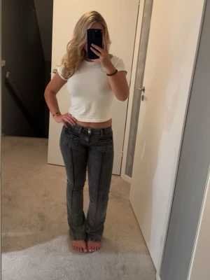 Grå bootcut jeans med kontrastsömmar - Jag säljer dessa grå/svarta Nelly jeans med fickor både fram och back. Dom är i väldigt bra skick och är bra i längd för mig som är 160😍😍