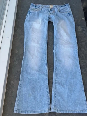 Ljusblå bootcut jeans från B.Mone - Så snygga jeans som tyvärr inte passar min och har därför ingen bild på! Midjemått tvärsöver: 41cm Midjehöjd: 17cm innerbens längd: 77cm. Finns några svaga fläckar, se de sista bilderna men de är väldigt svåra att se! 💕🩷💕