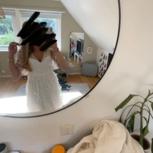 Vit blommig kortklänning med v-ringning - Superfin vit kortklänning med 3D-blommor och v-ringning. Klänningen har genomskinliga korta ärmar och en lätt utsvängd kjol. Perfekt för sommarens tillfällen och student. Materialet känns luftigt och romantiskt. VID SNABB AFFÄR 450KR!!!