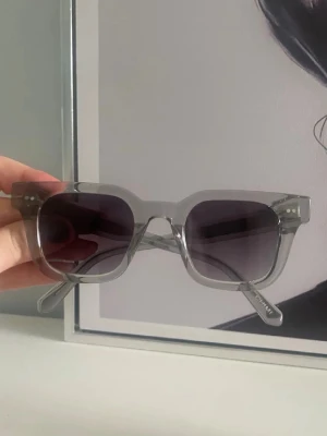 Chimi solglasögon  - Snygga solglasögon från CHIMI med transparent grå båge och mörka fyrkantiga glas. Klassisk och trendig design som passar till många stilar. Kommer med originalfodral från CHIMI. Modellen 04, dom är knappt använda då jag inte tycker dom passa mitt ansikte så dom är som helt nya, priset går att diskutera vid snabb affär