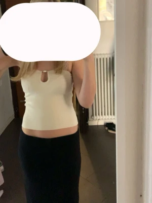 Topp med pärldetalj - Supersnygg ljus ribbad topp med pärldetalj framtill och liten cut-out vid halsen. Passar superbra till sommaren! Kontakta mig gärna vid frågor💕