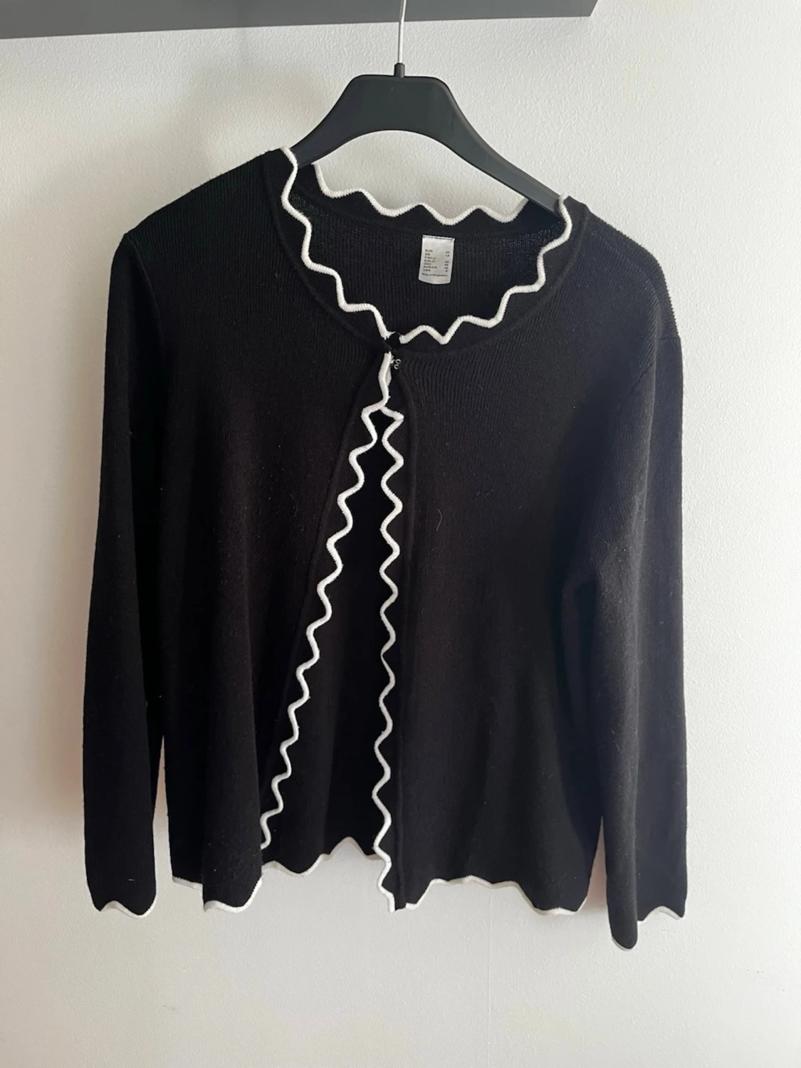 Svart kofta med vågig kant