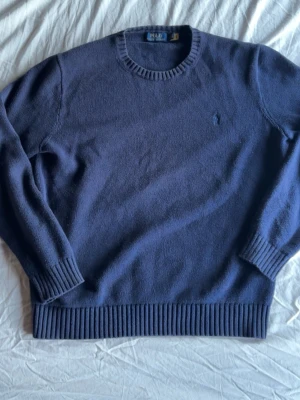 Ralph Lauren stickad blå tröja - Mörk blå stickad Ralph Lauren tröja i 9/10 kvalité. Den är i storlek L och har inge defekter. Äkthets bevis finns