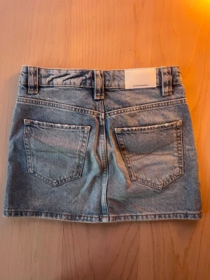 Blå jeanskjol - Säljer en blå jeanskjol från Stradivarius med två bakfickor. Kjolen har en kort modell med låg midja och slitningar. Skitsnygg för ett skitbra pris💸😍