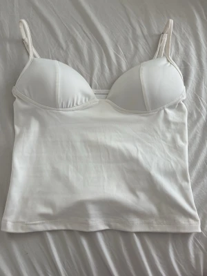 Vit topp med inlägg - Vit topp med inlägg i kuporna, storlek S. Användes en gång