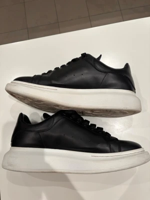 Svarta sneakers av Alexander McQueen  - Säljer ett par svarta sneakers från Alexander McQueen i otroligt bra skick, använde en gång men säljer dem nu då de va för små. Men dock finns de ej dustbag eller box då vi slängde (där av priset). Väldigt sköna skor och perfekt nu till våren. Skriv till mig för mer info! Pris kan alltid diskuteras 😇