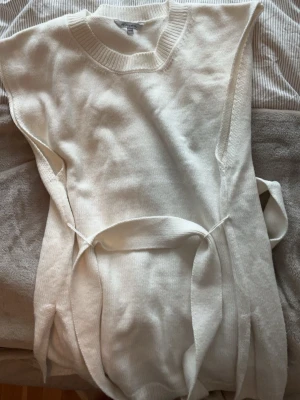 Vit stickad tröja med midjeband  - Vit sticks kortärmad tröja med ett band som går att knyta i midjan, slita på sidan. Aldrig använd 