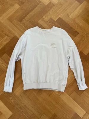 Beige sweatshirt med tryck - En stilren beige sweatshirt i mjuk bomull med rund halsringning och diskret texttryck på bröstet. Maja Nilsson Lindelöf x Ginatricot