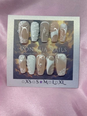 IvorySkin (M);Medium Ballerina - Snygga handgjorda press-on naglar i storlek M. Naglarna har en beige och vit bas med abstrakta mönster, handmålade 3D-effekter och silverdetaljer. Formen är medium långa ballerinaform. Perfekt för dig som vill ha unika och trendiga naglar.