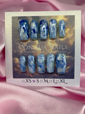 Azure (S);Medium Square - Unika handgjorda press-on naglar i blåcateye och vita toner med detaljerade havsmotiv och bubblor. Naglarna har en medium lång squareform och skimrande inslag som ger en drömmig look. Perfekt för dig som vill ha något konstnärligt och speciellt.S: 15 mm, 11,5 mm, 12 mm, 11 mm, 9 mm 