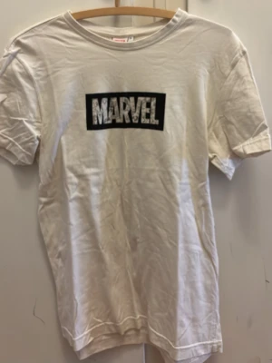 Vit Marvel t-shirt med tryck - Säljer en vit oversized t-shirt från Marvel med stort svart och vitt Marvel-tryck på bröstet. Storlek S.