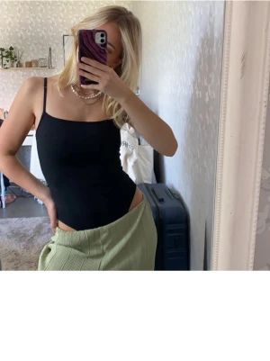Svart body Gina tricot  - Säljer en svart, tight body i figursydd form. Materialet är skönt och banden justerbara. Perfekt basplagg. Storlek xs, passar även mig som har S då den är stretchig och anpassar sig. Gina tricot. 