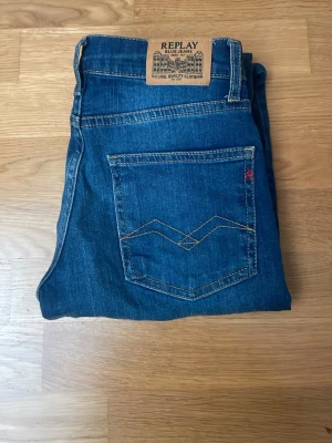 Blå jeans från Replay - Snygga blå jeans från Replay med klassisk femficksdesign och raka ben. Jeansen har kontrastsömmar. 