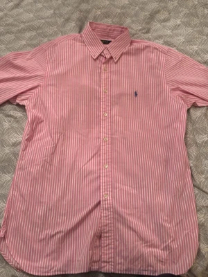 Rosa randig skjorta från Polo Ralph Lauren - Nice sommar skjorta i bra färg. Köp om du vill ha något nice i sommar och kan gå ner lite i pris vid snabb affär. Som ny och jätte bra kvalité