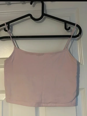 Ljusrosa linnetopp - Säljer en ljusrosa linnetopp med smala axelband. Enkel, stilren och lätt att matcha med både jeans och kjol. Perfekt som basplagg eller att bära under en kofta eller kavaj (ifrån new yorker) 