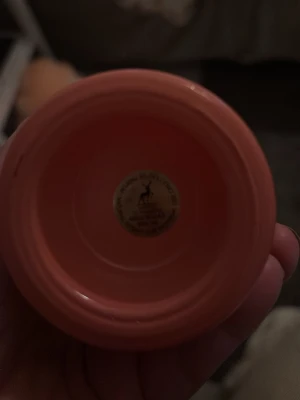 Oasis parfymflaska i korallrosa - Säljer en snygg parfymflaska från Oasis i en unik korallrosa färg med gulddetaljer och ett dekorativt mönster på framsidan. Flaskan har en rund form och ett guldfärgat lock med en liten tofs. Perfekt för dig som gillar stilrena och färgglada accessoarer.