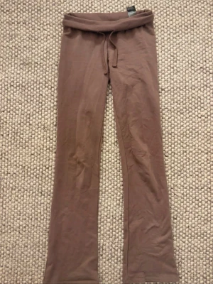 Mjukisbyxor Nelly  - Bruna bootcut lågmidjade byxor från Nelly!