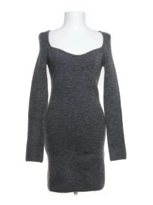 Mörkgrå stickad klänning - Mysig mörkgrå stickad klänning med lång ärm och figurnära passform. Klänningen har en bred, något djupare urringning och är tillverkad i ett mjukt stickat material som passar perfekt för kyligare dagar.